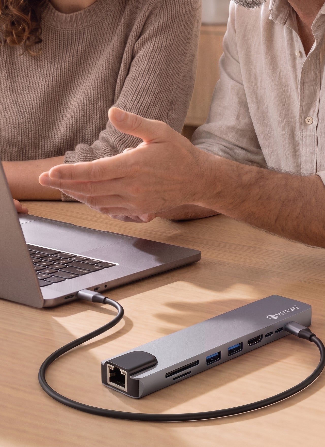 Twee mensen werken aan een laptop die via een Switss® 8-in-1 USB-C hub is aangesloten