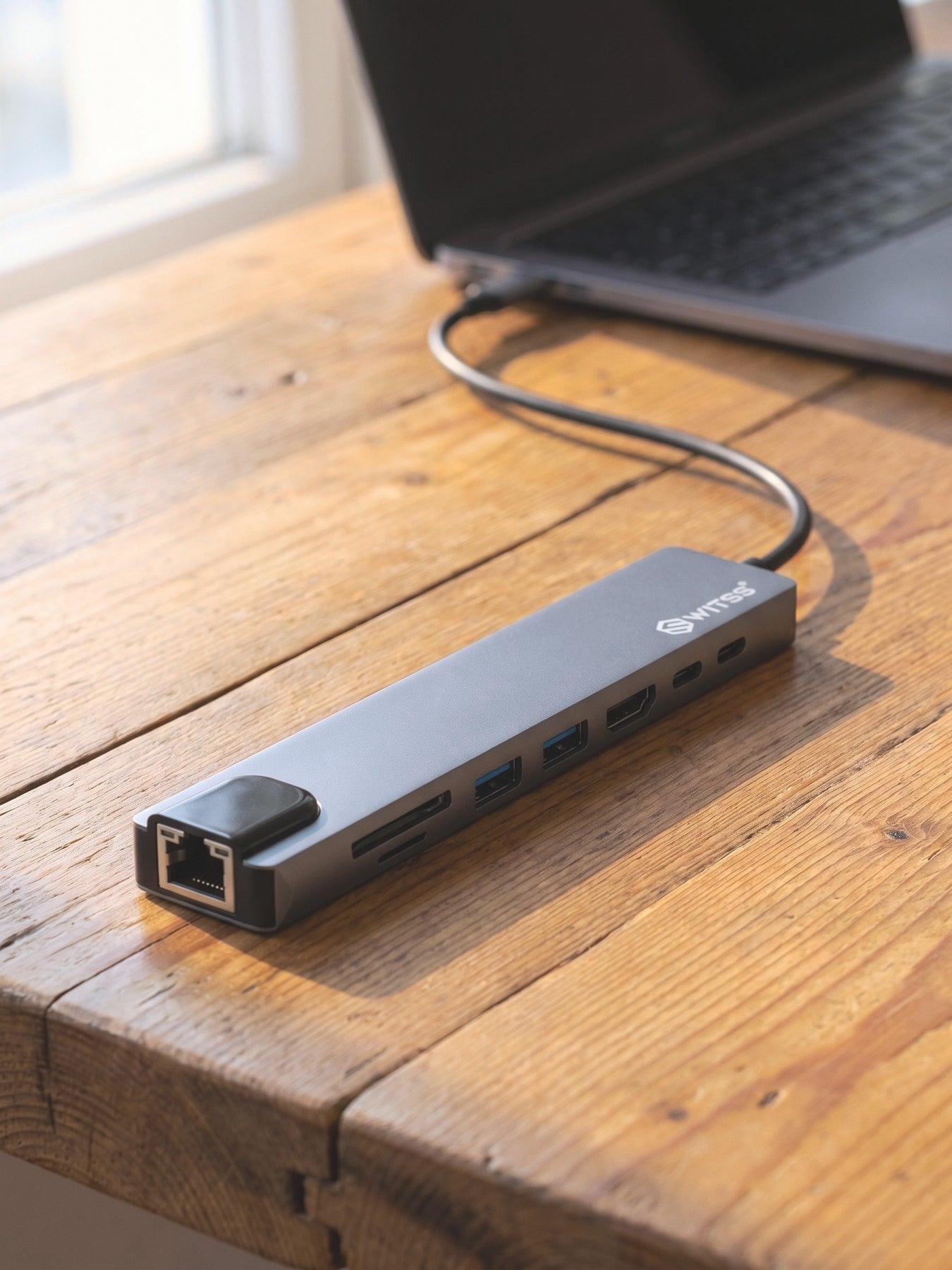 Switss® 8-in-1 hub aangesloten op een laptop, compact op een bureau