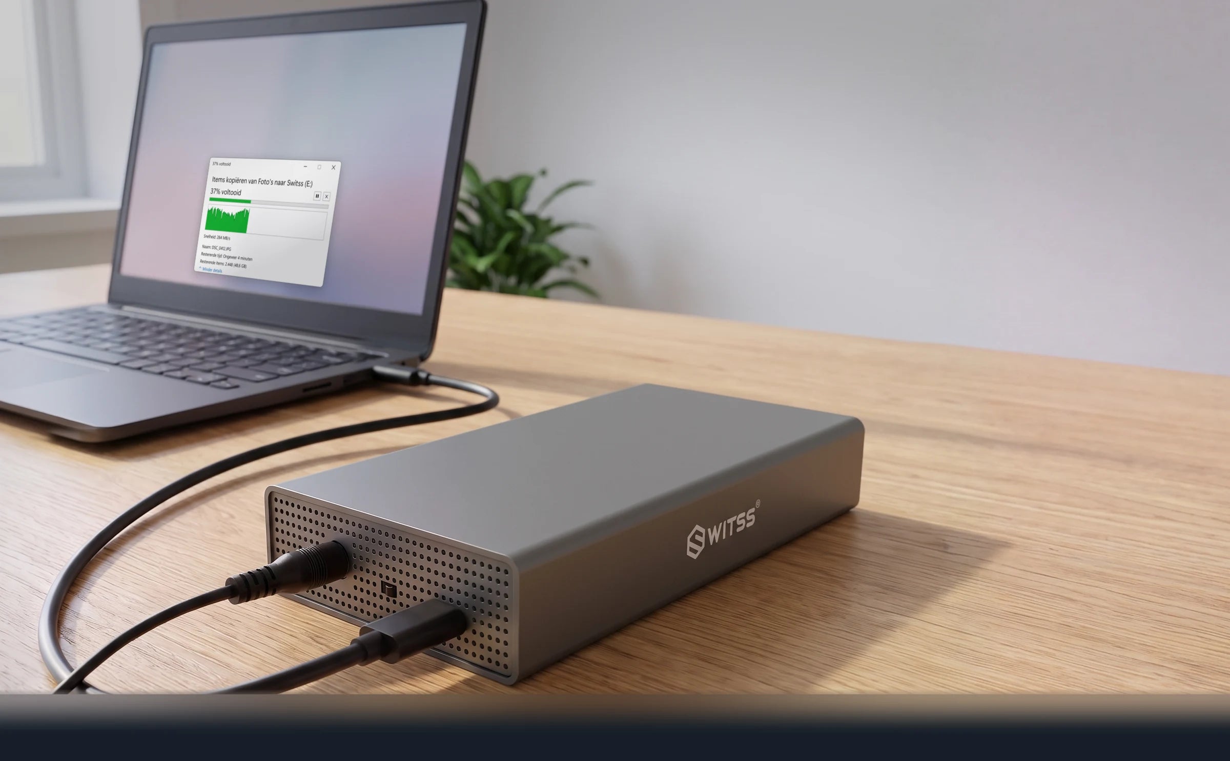 De Switss 3,5 inch behuizing aangesloten op een laptop, met op het scherm het venster van een lopende kopie naar de schijf