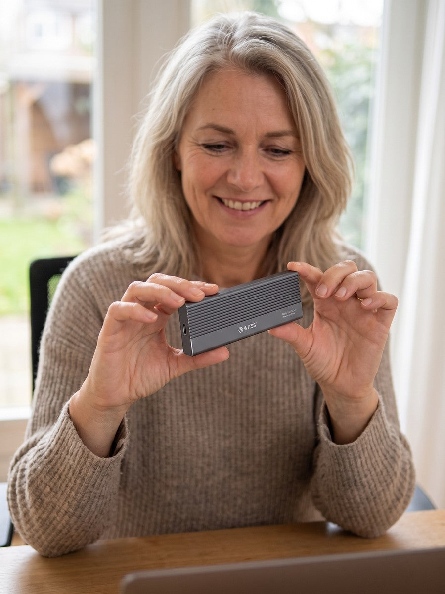 A woman holds the Switss M.2 enclosure in her hands at a table